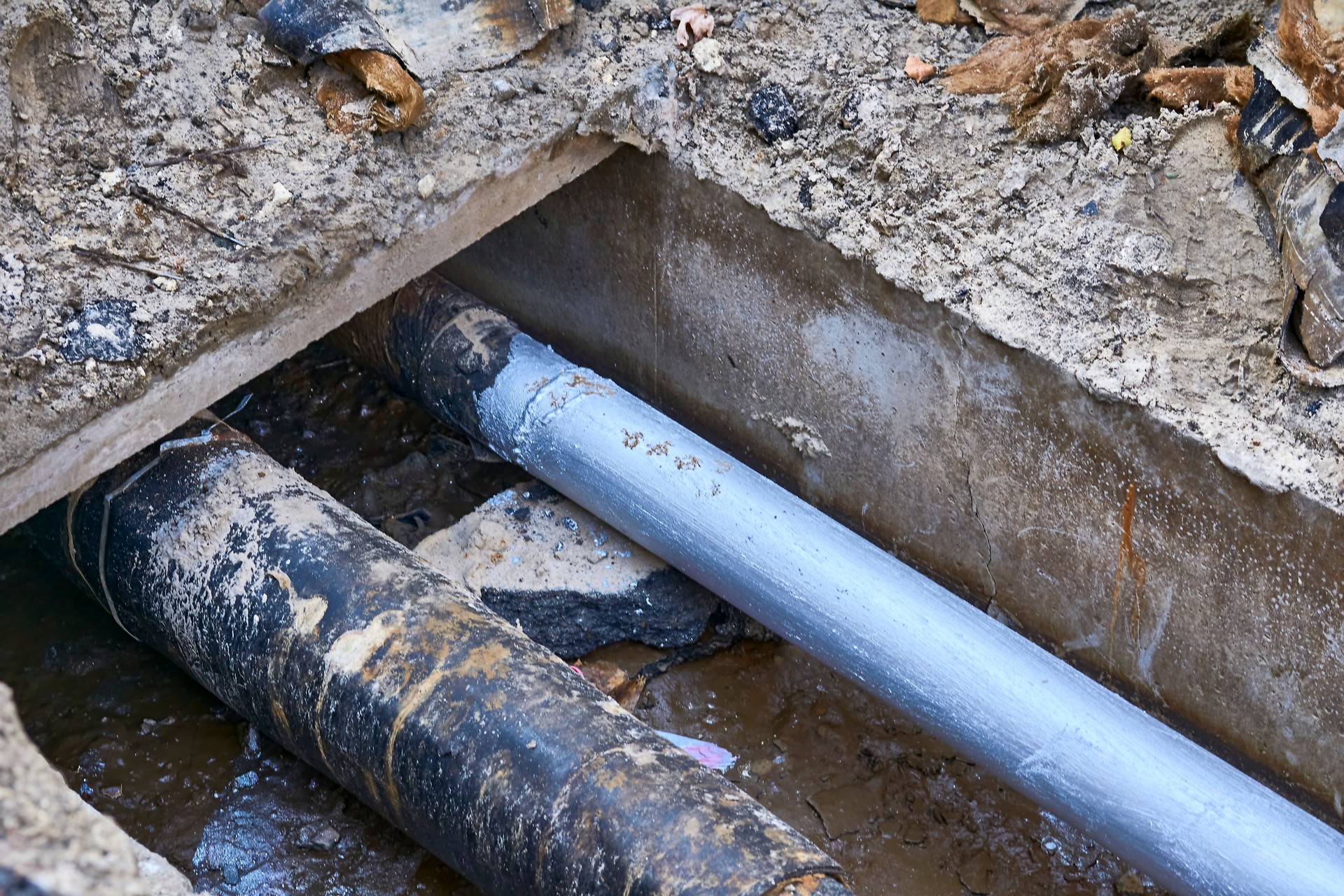 Excavated pit with plastic plumbing sewage pipes for repair and installation